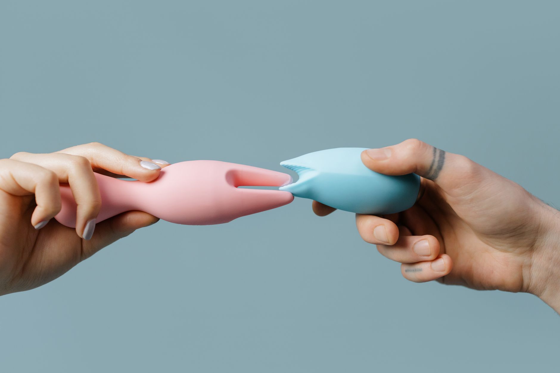 Un vibrateur citron bleu tenu en main sur fond violet, symbole de l'auto-découverte et du plaisir