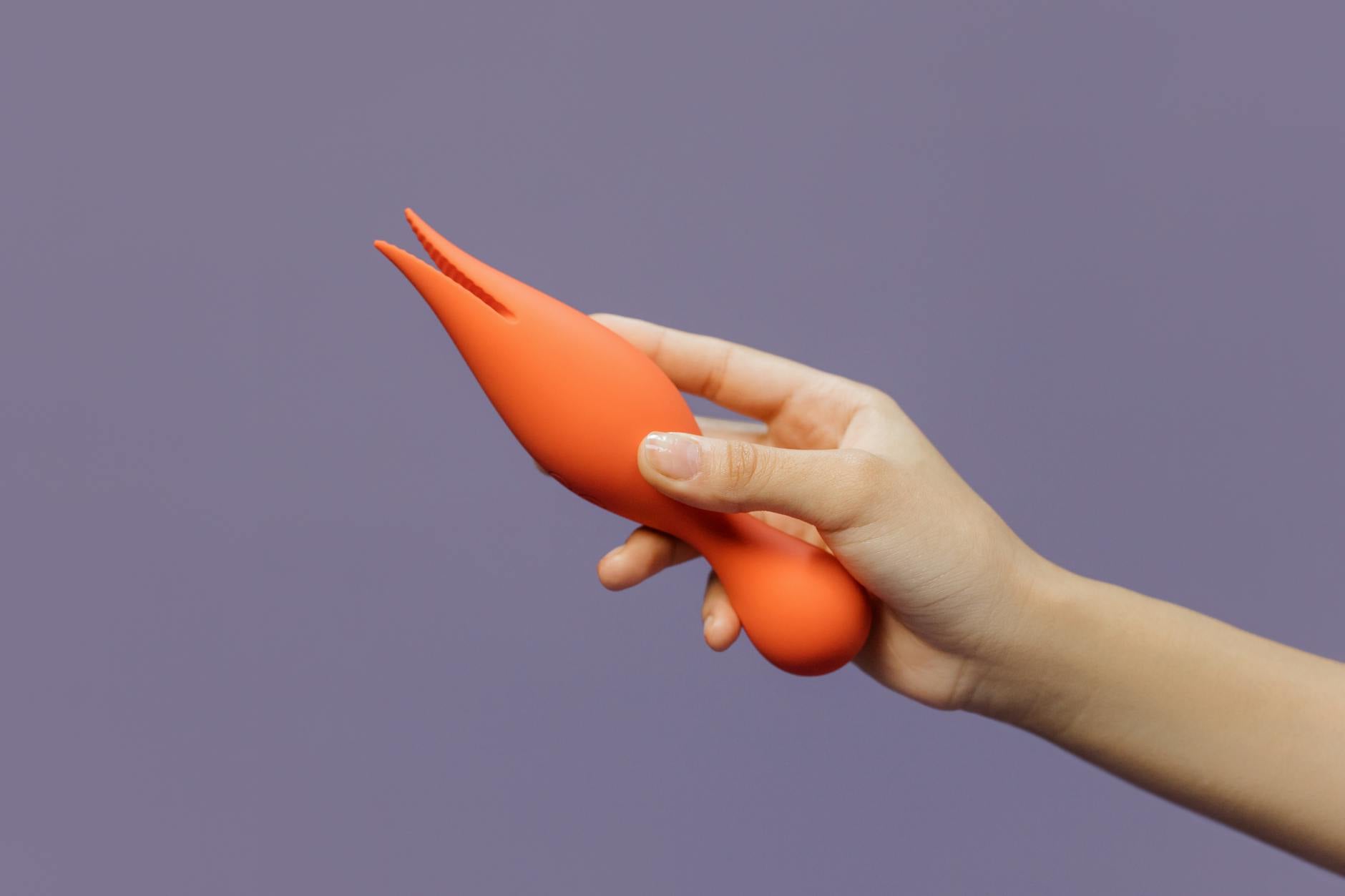 Une main tenant un vibrateur citron moderne contre un fond minimaliste, mettant en avant la sensualité contemporaine.