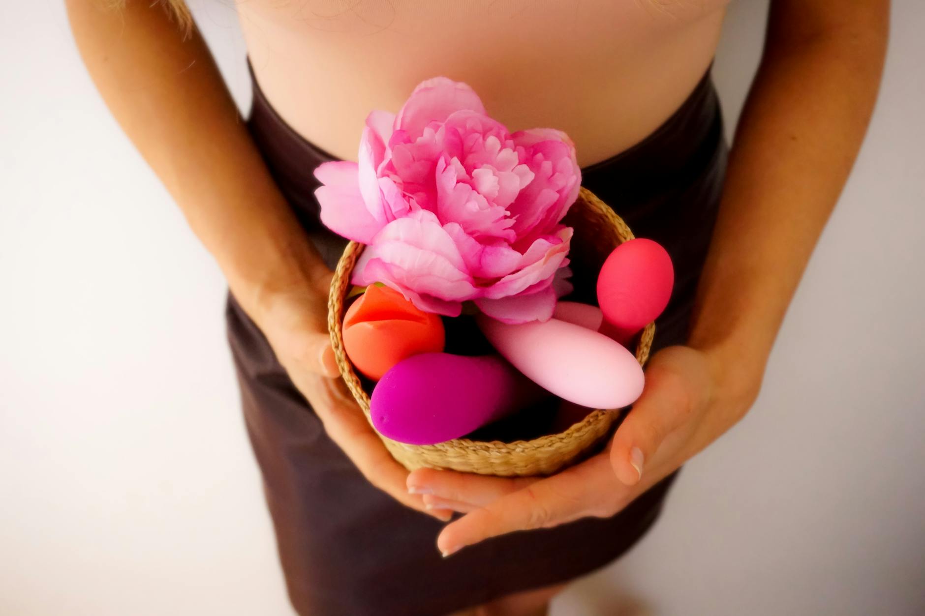 Un panier rempli de vibrateurs colorés et une fleur rose, symbolisant le retour au plaisir personnel